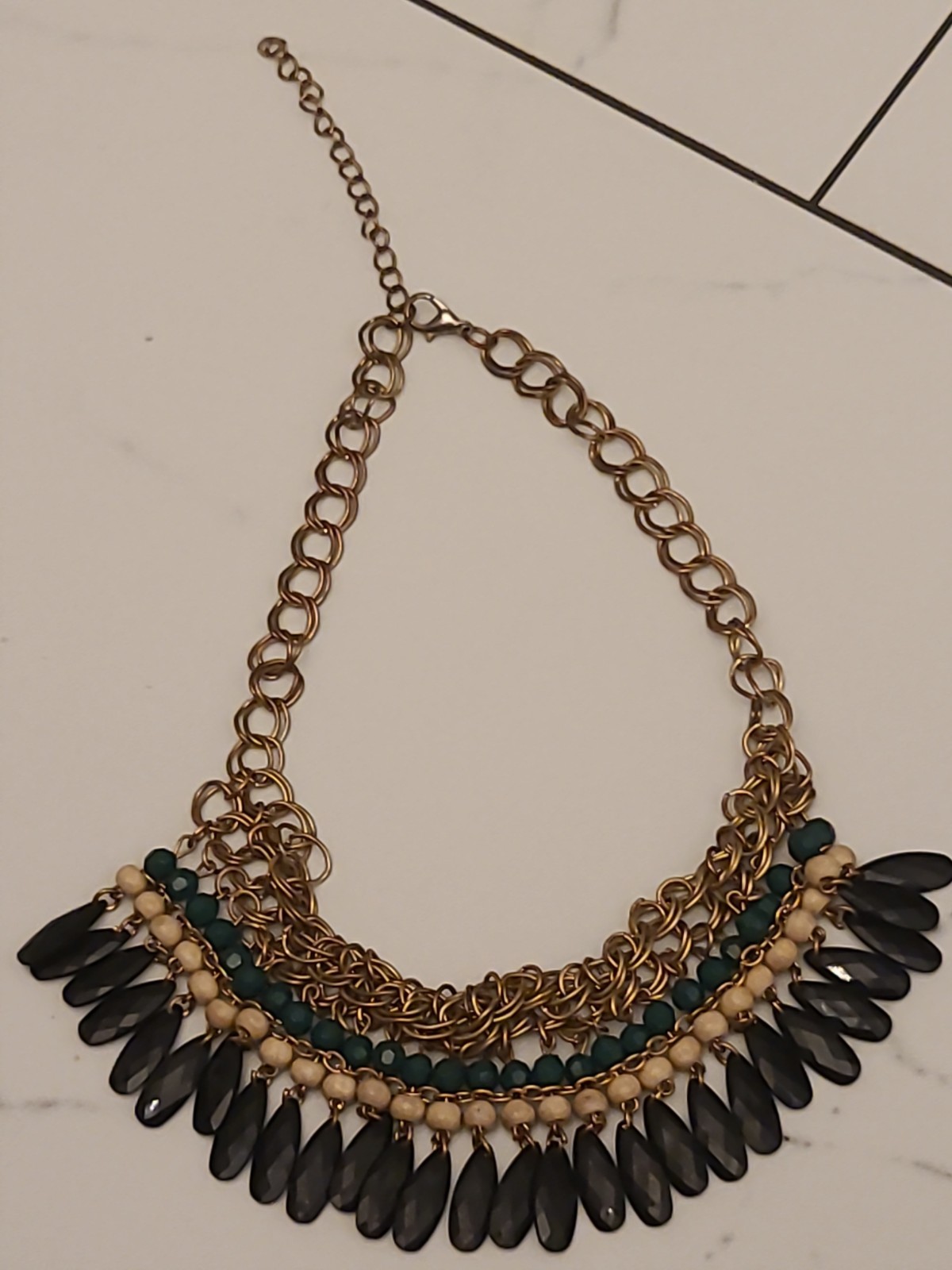 Metal alloy statement bib necklace with black resin beads and gold-tone chain